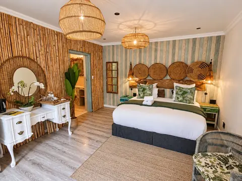 CapeAura King Suite bedroom with woven lamps, a bamboo wall and green accents