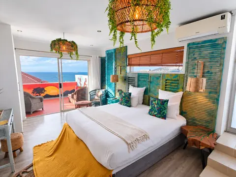 CapeAura sea-view suite with turquoise shutters, a king bed and a private ocean-view terrace